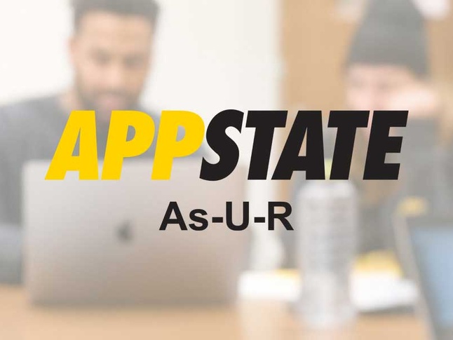 App State As-U-R logo with faded background of students working on computer. 